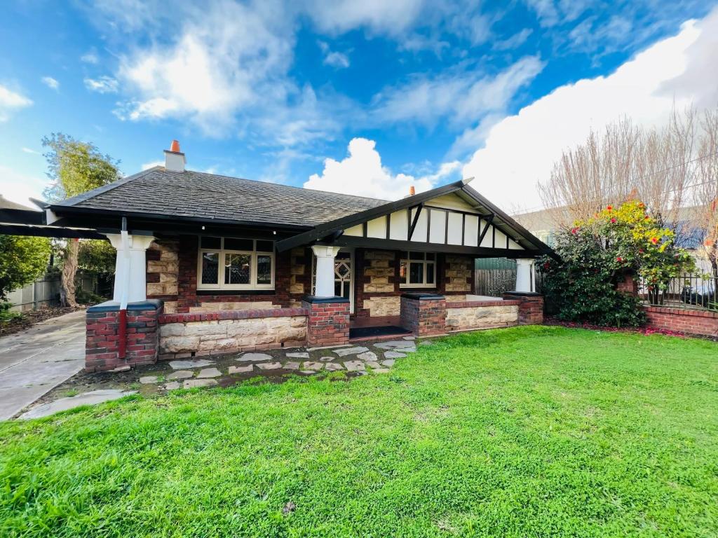 een huis met een groen gazon ervoor bij Group house with views of the salt pool and spa in Mitcham