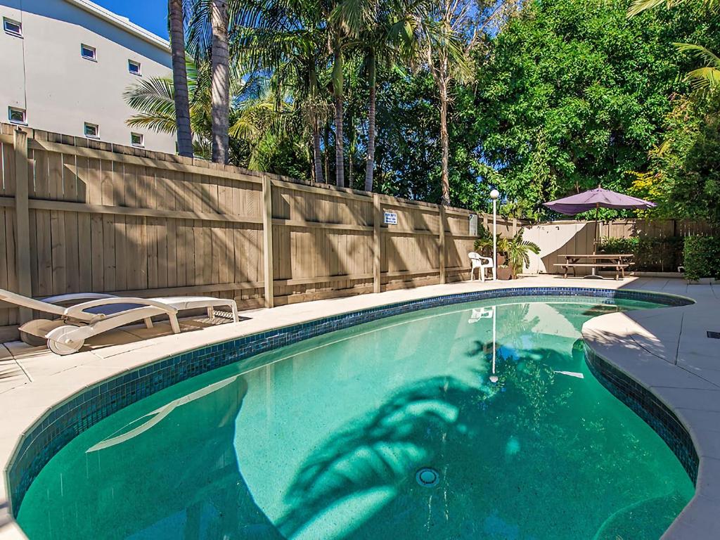 a swimming pool with a persons reflection in the water at Unit 2 Riverbreeze in Noosaville