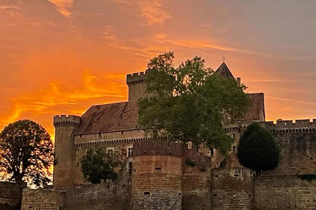 un vieux château avec un coucher de soleil en arrière-plan dans l'établissement holiday home Chateau Castelnau, à Prudhomat