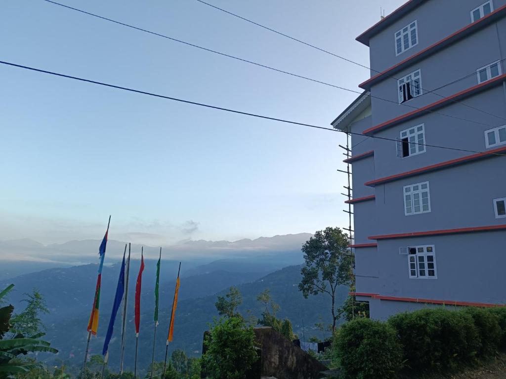 un edificio sul fianco di una montagna con bandiere di HOTEL SILVER a Pakhyong