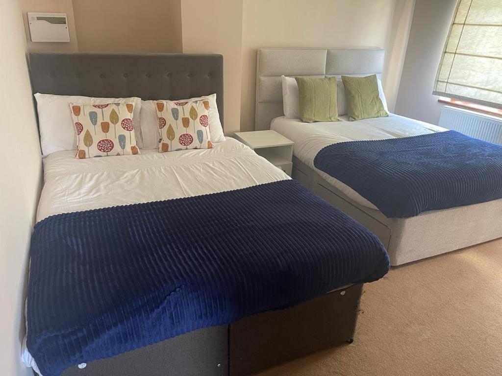 a bedroom with two beds with blue and white sheets at Shared house on Southmead in Bristol