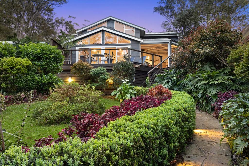 una casa con un jardín delante de ella en Scotland Island Lodge, en Scotland Island