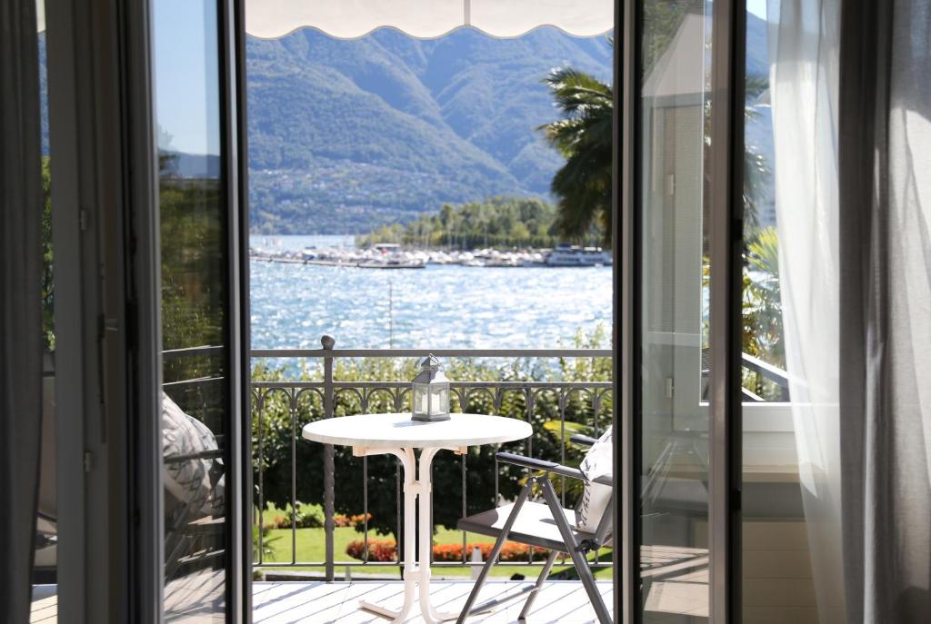 a balcony with a view of the water and mountains at Al Pozz Boutique Resort in Locarno