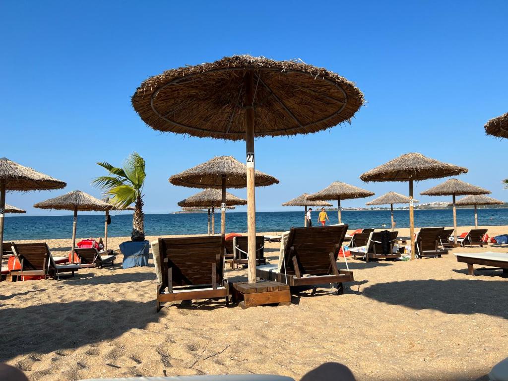 a group of chairs and umbrellas on a beach at Camping Gradina Garden Beach b33 in Chernomorets