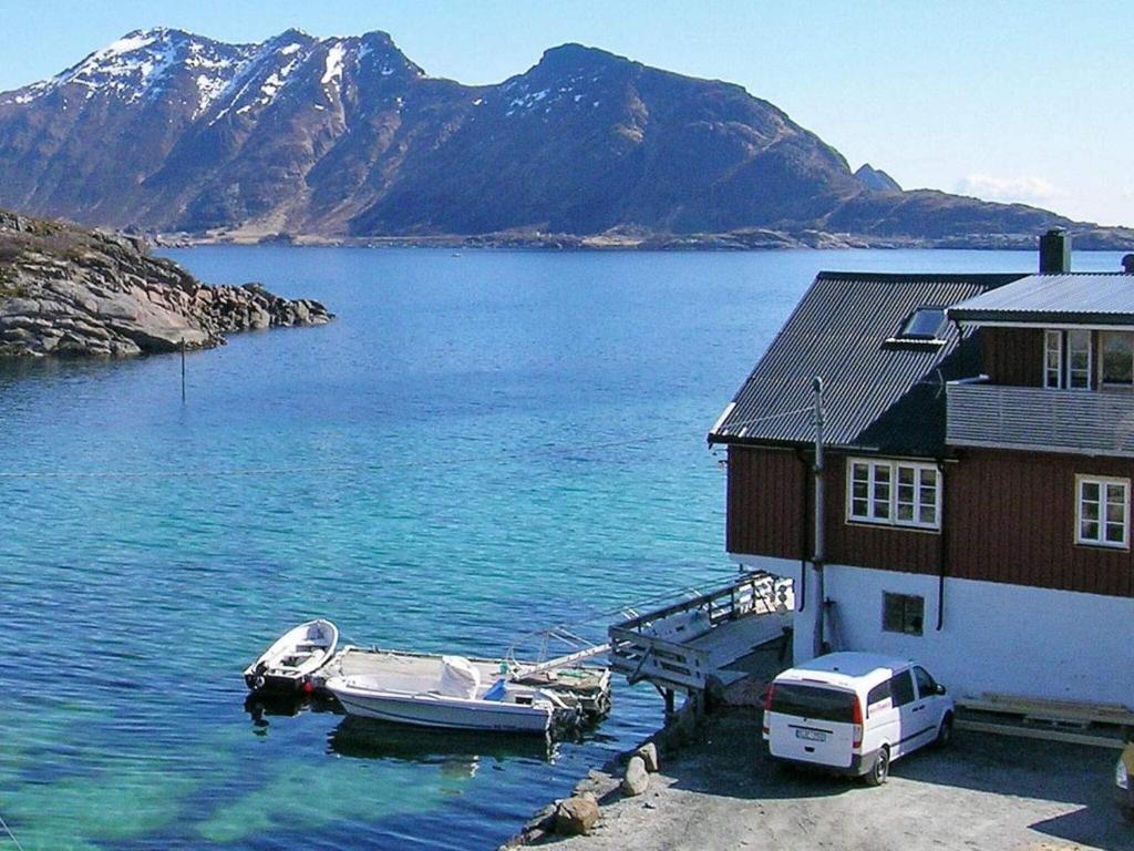 a boat is docked next to a house on the water at Two-Bedroom Holiday home in Gravdal 1 in Gravdal
