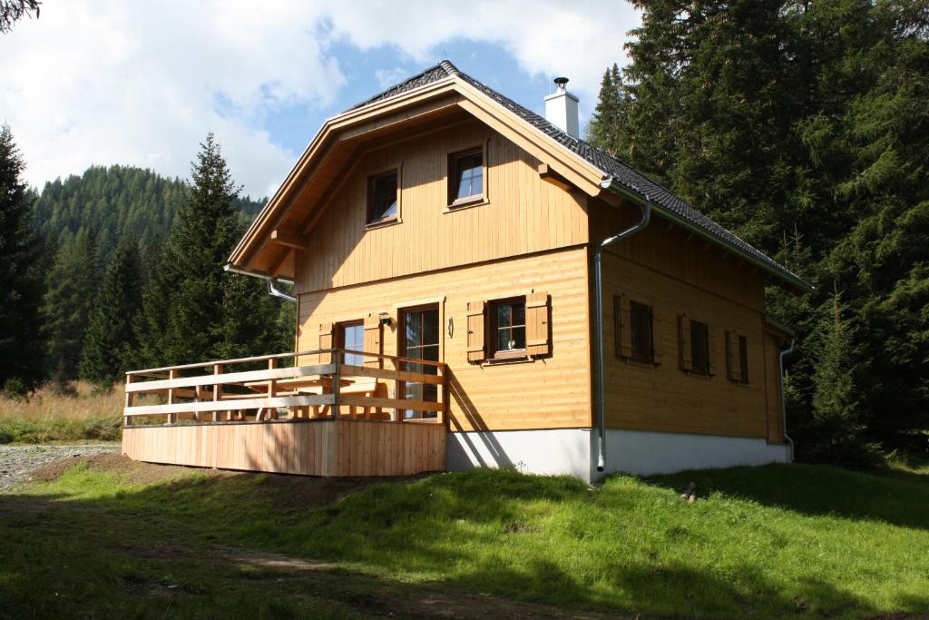 une maison sur une colline avec une terrasse en bois dans l'établissement Hüttentraum Flattnitz, à Flattnitz