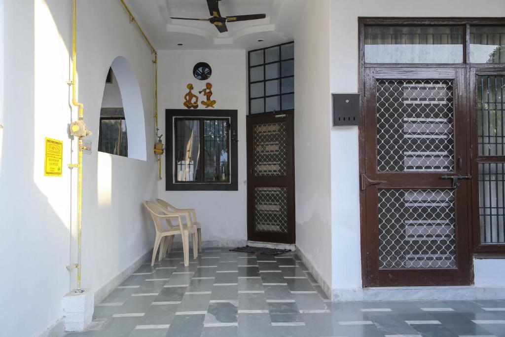 a room with a door and a chair and a floor at Aradhanas Home Stay Near Taj Mahal in Agra