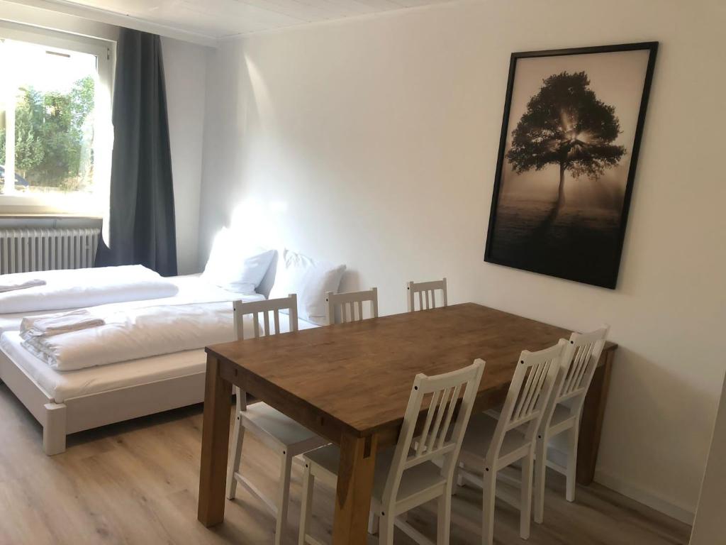 a dining room with a table and chairs and a bed at Ferienwohnung in der Sanderau in Würzburg