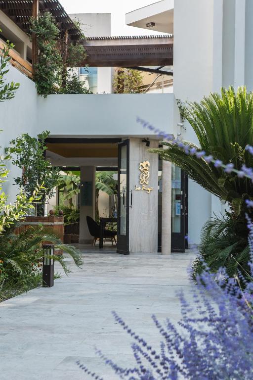 a lobby of a building with plants and flowers at Hôtel La Roya in Saint-Florent