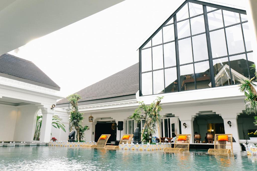 a swimming pool in front of a building at MAHALAYA The Legacy Hotel in Solo