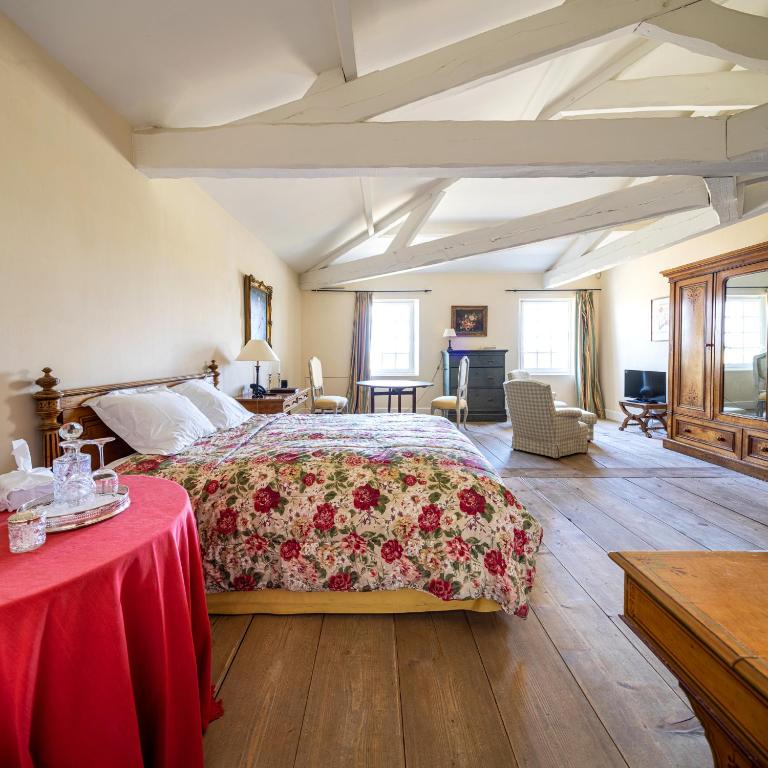 a bedroom with a large bed with a red blanket at Château du Tertre in Arsac