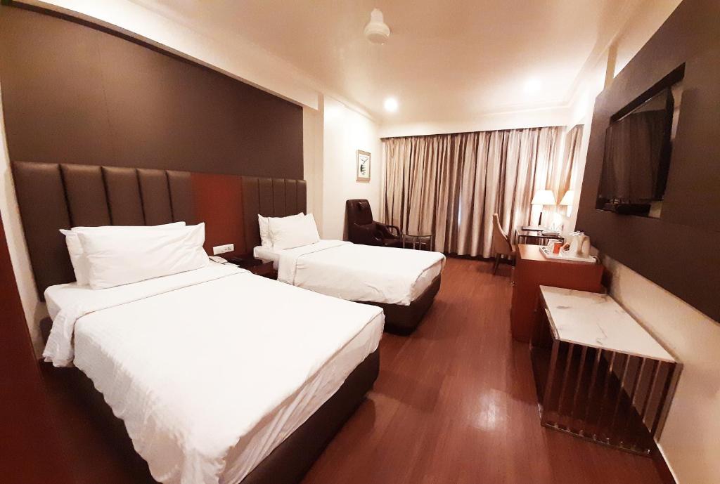 a hotel room with two beds and a television at Fortune Murali Park, Vijayawada - Member ITC's Hotel Group in Vijayawāda