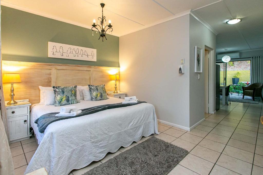 a bedroom with a large bed with a wooden headboard at Eldorado Private Collection in Oudtshoorn