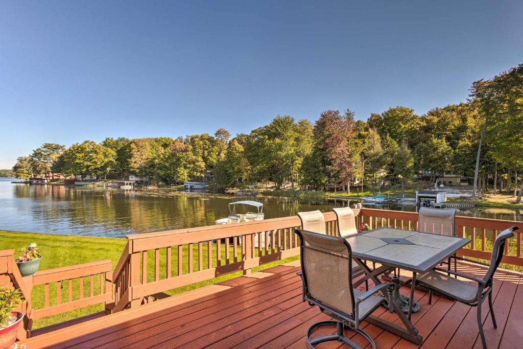 a wooden deck with a table and chairs on it at Lakefront Ludington Retreat with Kayaks and Fire Pit! in Ludington