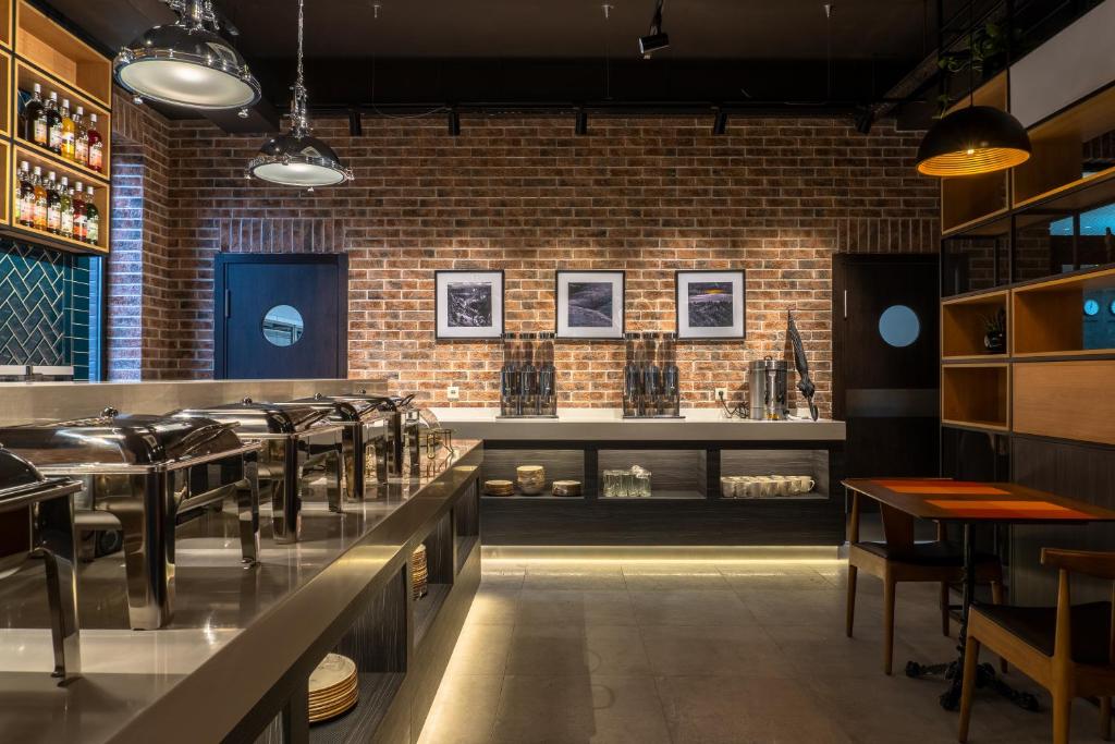 a restaurant with a brick wall and tables and chairs at Resident Hotel Kazybek Bi in Almaty