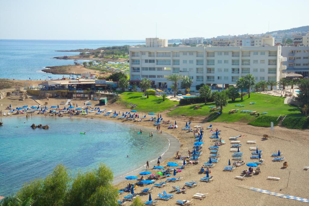 a beach with a bunch of chairs and umbrellas at Pola Costa Beach Hotel Apts - Adults Only in Protaras