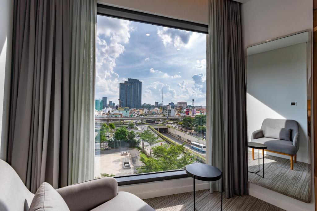 Zimmer mit einem großen Fenster und Stadtblick in der Unterkunft Hello World Saigon in Ho-Chi-Minh-Stadt