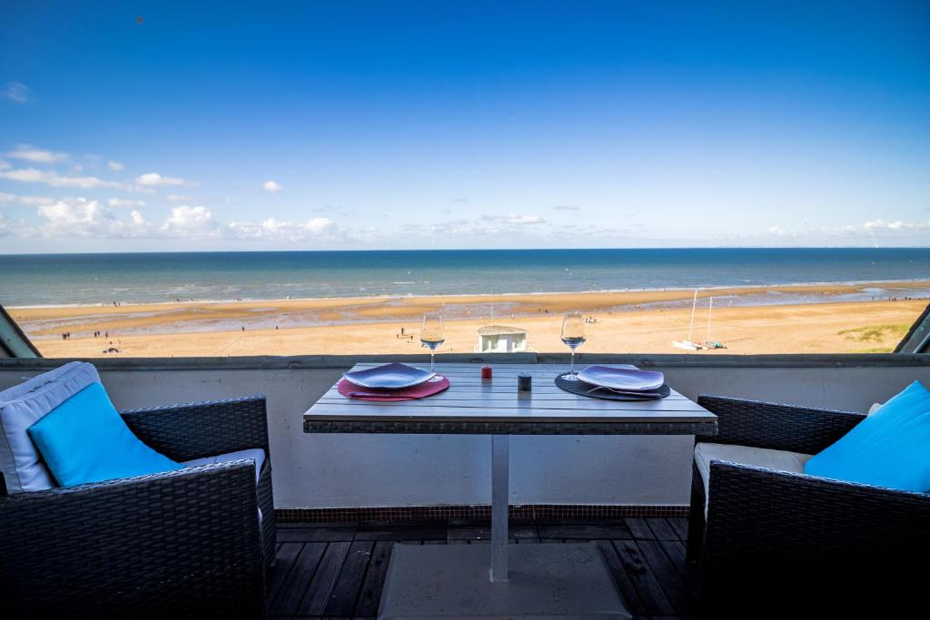 une table sur un balcon avec vue sur la plage dans l'établissement Havre de paix à deux pas de la plage - Arrivée autonome, Parking privé et gratuit, à Varaville