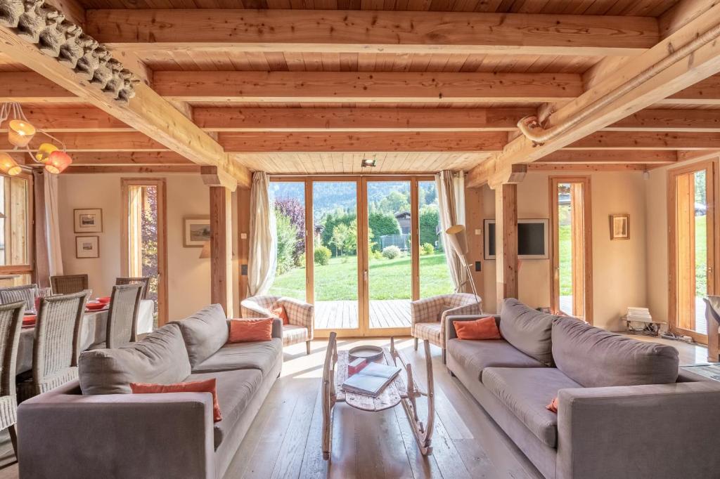 a living room with couches and a large window at Chalet Athina in Les Houches