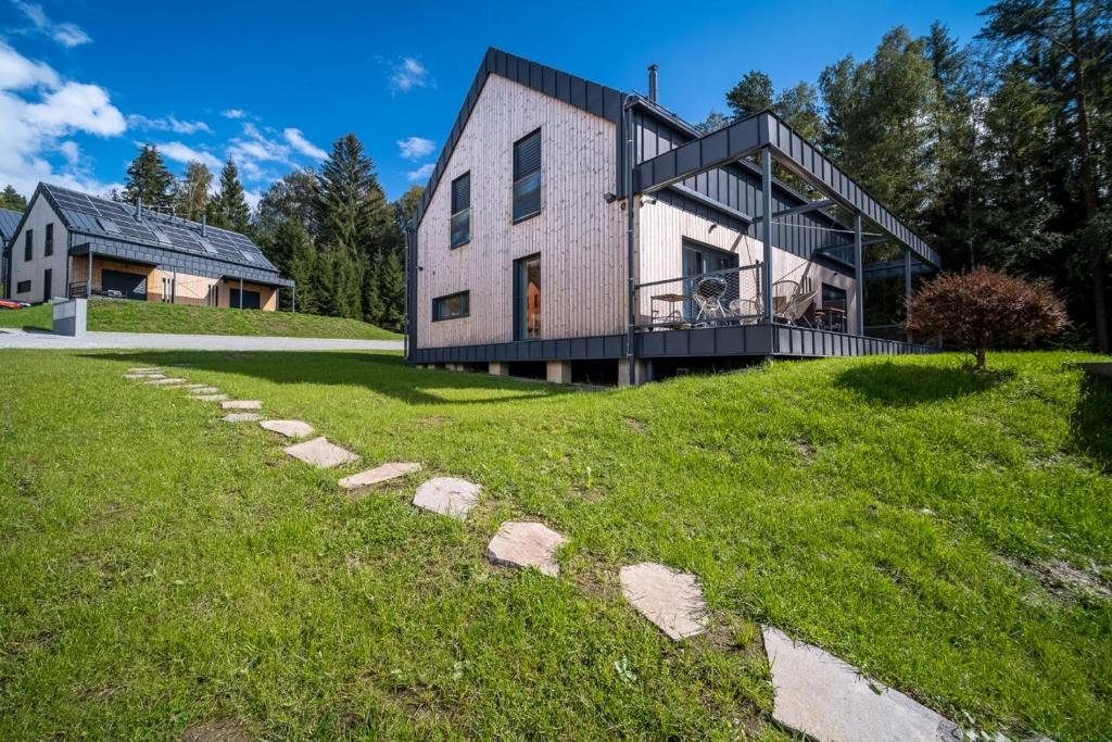 a house on a hill with a stone path leading to it at Holiday House U Hájenky 13P Lipno Home in Lipno nad Vltavou