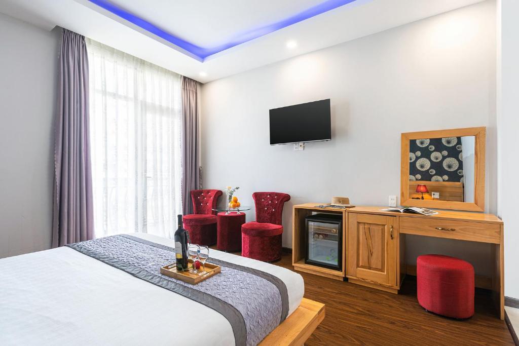 a hotel room with a bed and a television at Dalat Wind Hotel in Da Lat