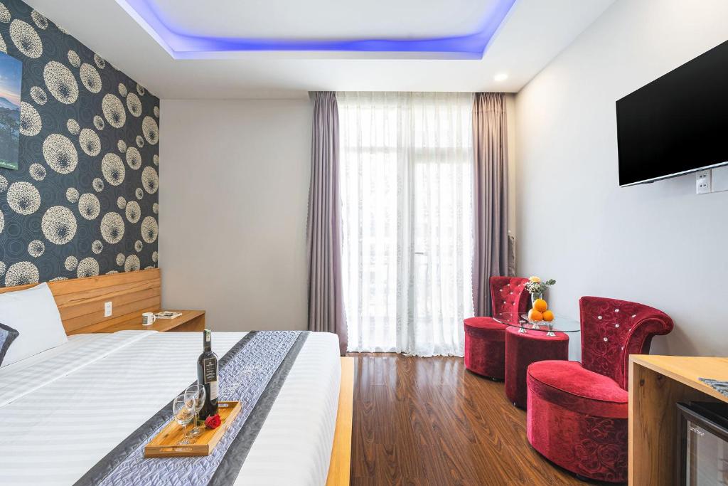 a hotel room with a bed and a tv at Dalat Wind Hotel in Da Lat