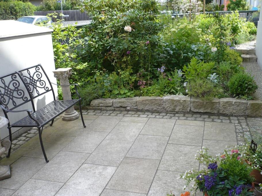 a patio with a bench and a garden with flowers at super zentral begehrte Wohnlage Parkplatz vor Haus in Nuremberg