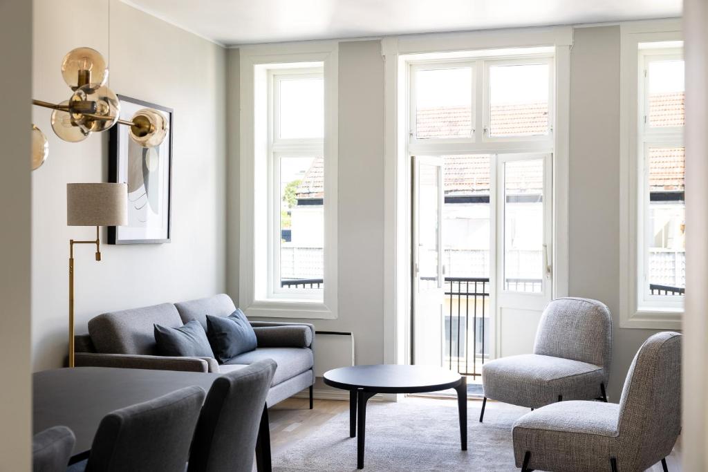 sala de estar con sofá, 2 sillas y mesa en Frogner House - Uranienborg en Oslo