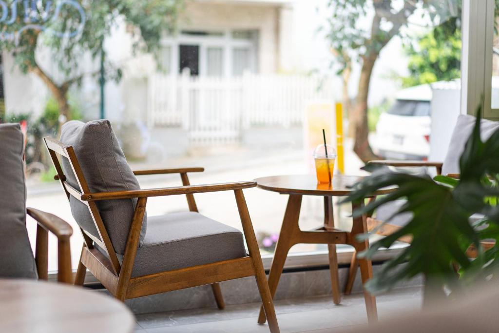 a table with chairs and a table with a drink on it at Dalat Wind Hotel in Da Lat