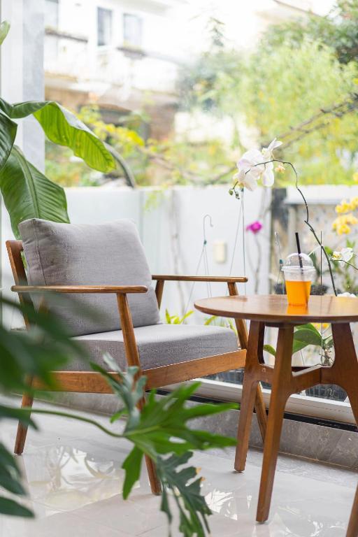 a chair and a coffee table on a balcony at Dalat Wind Hotel in Da Lat