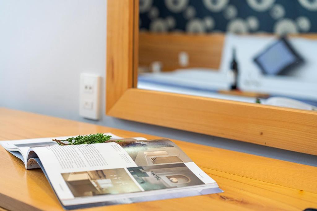 a magazine sitting on a table next to a mirror at Dalat Wind Hotel in Da Lat