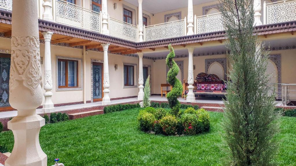 撒馬爾罕的住宿－Jahongir Premium，一座带绿色草坪的房屋的庭院