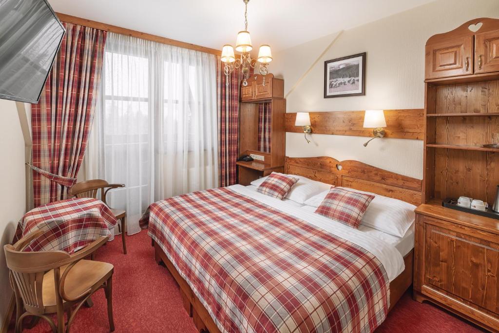 Habitación de hotel con cama y silla en Ski & Wellness Residence Družba en Demanovska Dolina