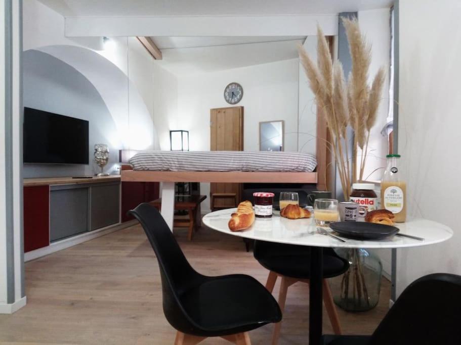 ein Wohnzimmer mit einem Tisch und einem Bett in der Unterkunft studio entre terre et ciel - escapade millavoise in Millau