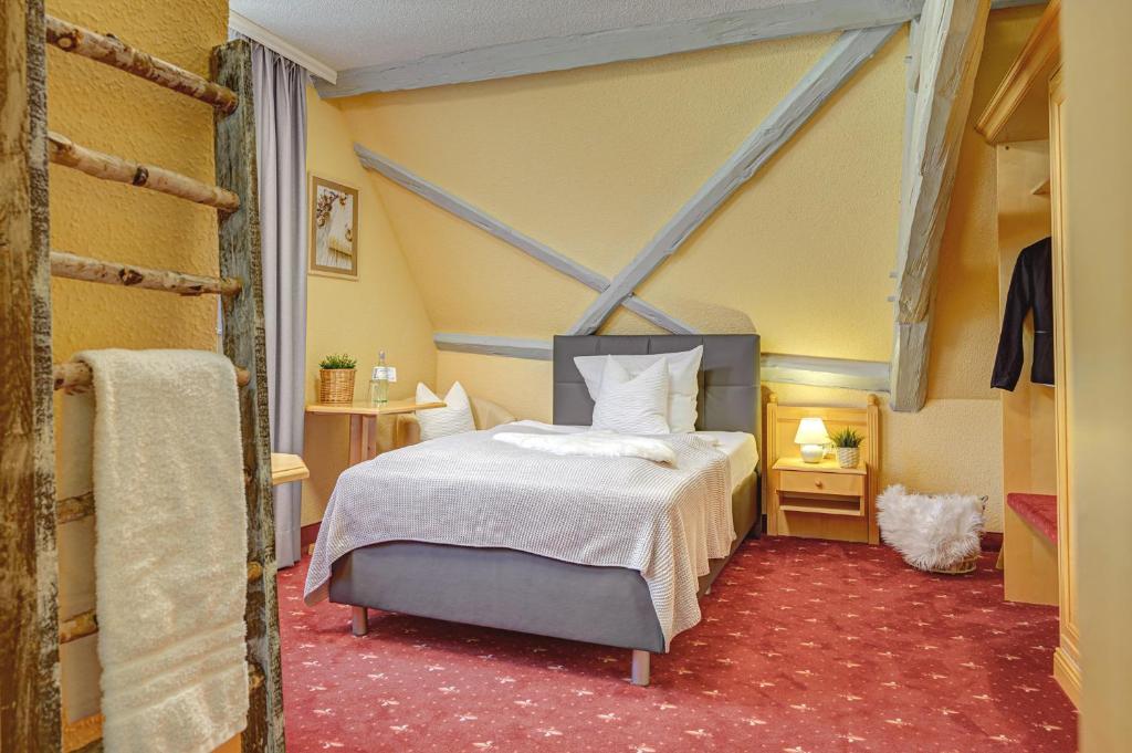 ein Schlafzimmer mit einem Bett in einem Zimmer in der Unterkunft Hotel Mühlhäuser Hof in Mühlhausen