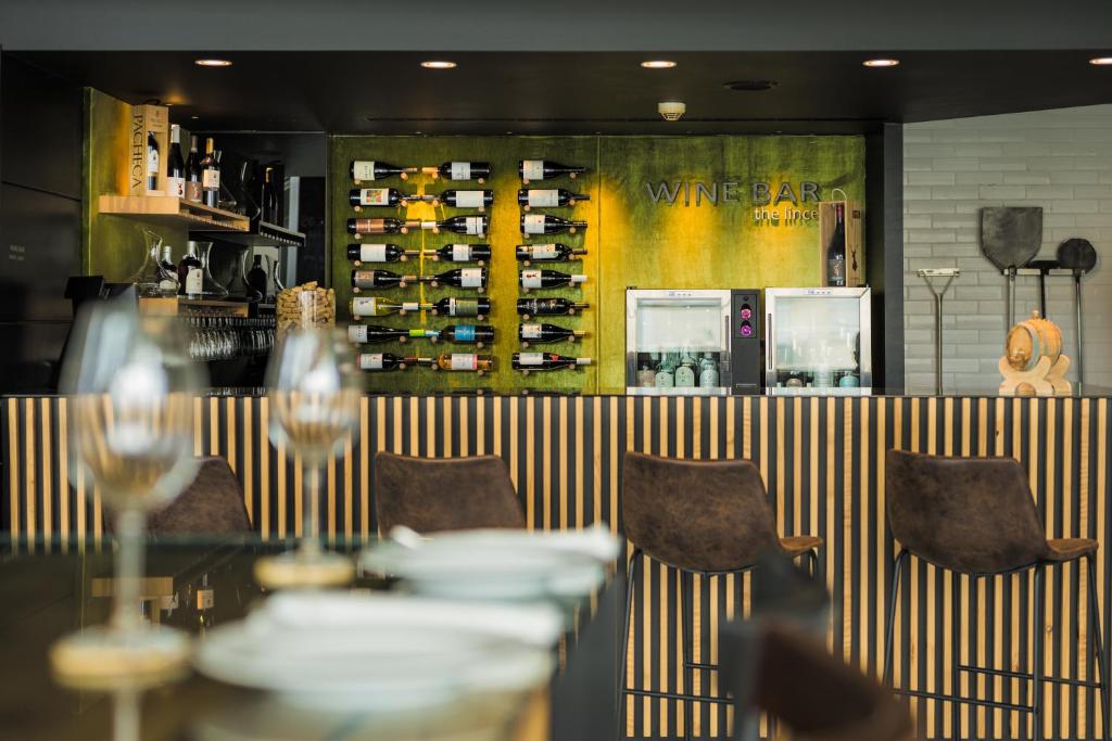 a restaurant with a table and chairs and a wine rack at The Lince Azores in Ponta Delgada