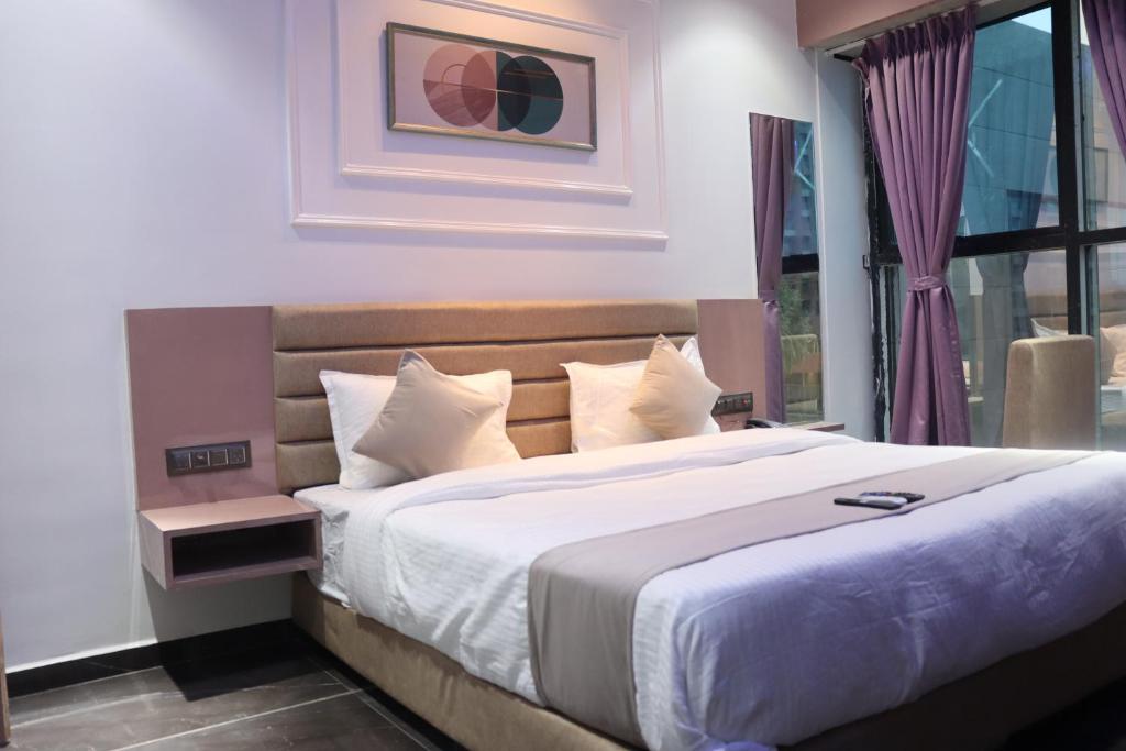 Un dormitorio con una cama grande y una ventana en Hotel Czar Inn, en Surat
