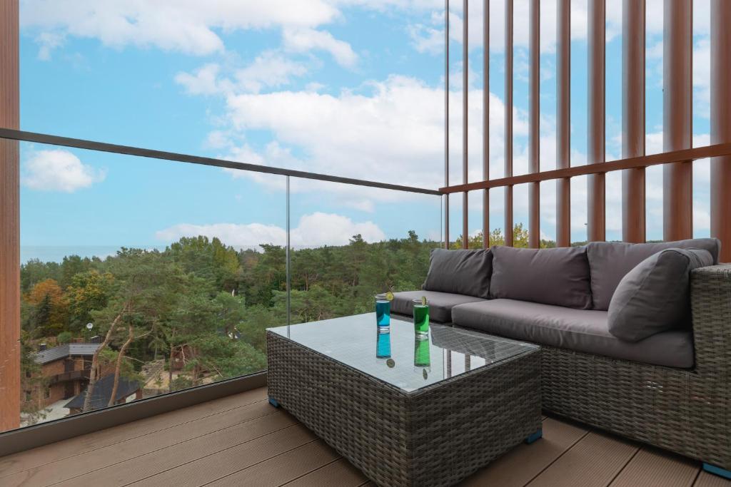 salon z kanapą i stołem na balkonie w obiekcie Apartments Mazowiecka Pobierowo by Noclegi Renters w Pobierowie