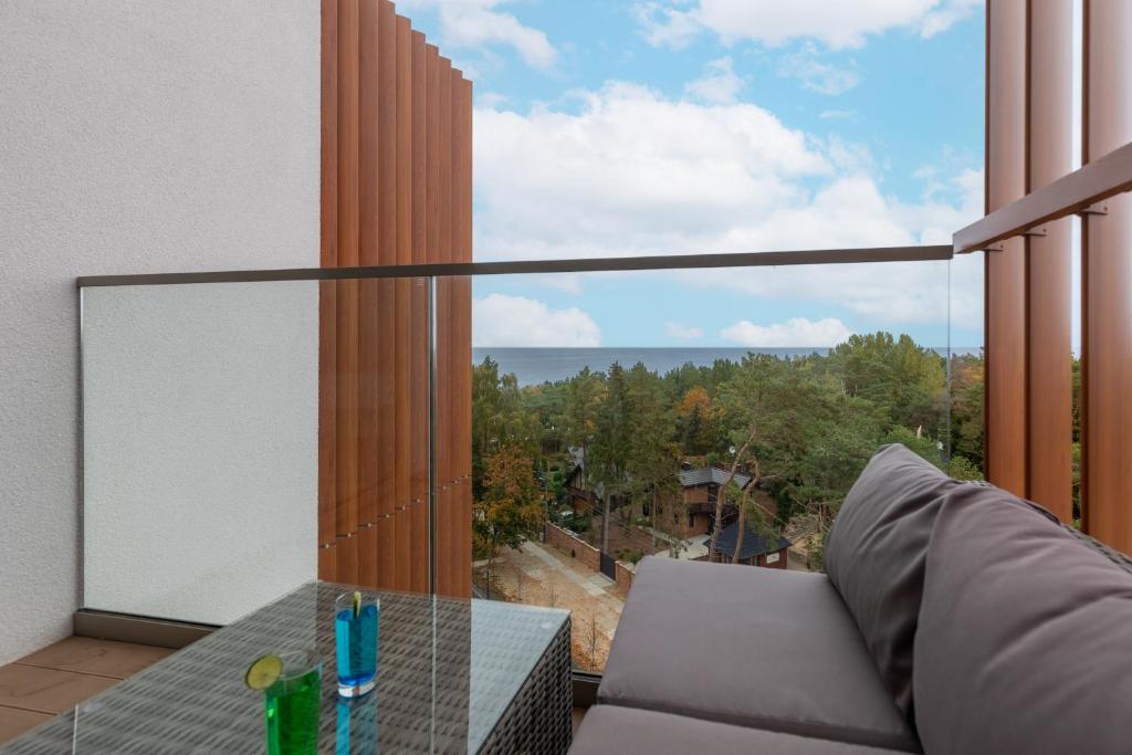 balkon ze stołem i dużym oknem w obiekcie Apartments Mazowiecka Pobierowo by Noclegi Renters w Pobierowie