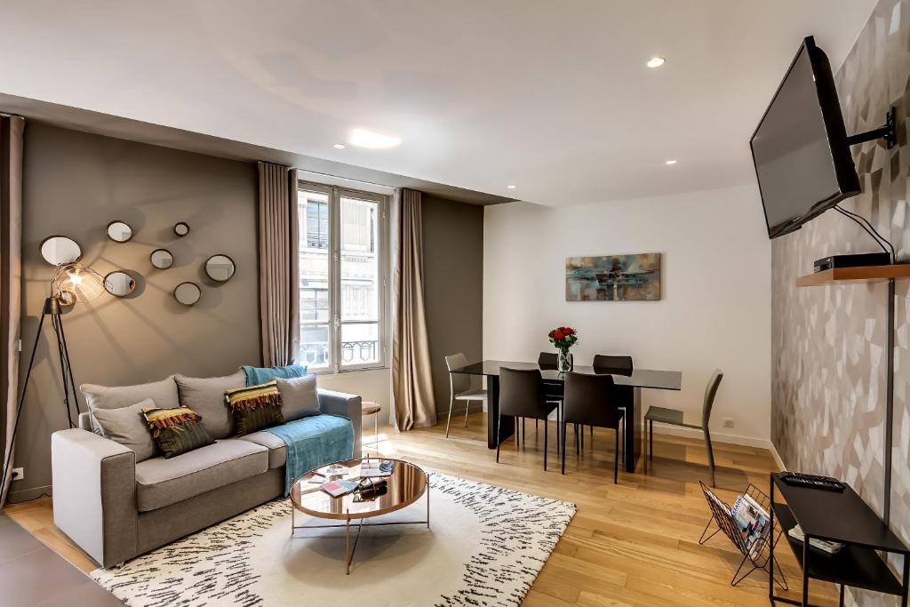 salon z kanapą i stołem w obiekcie Sweett - Parisian Allure w Paryżu