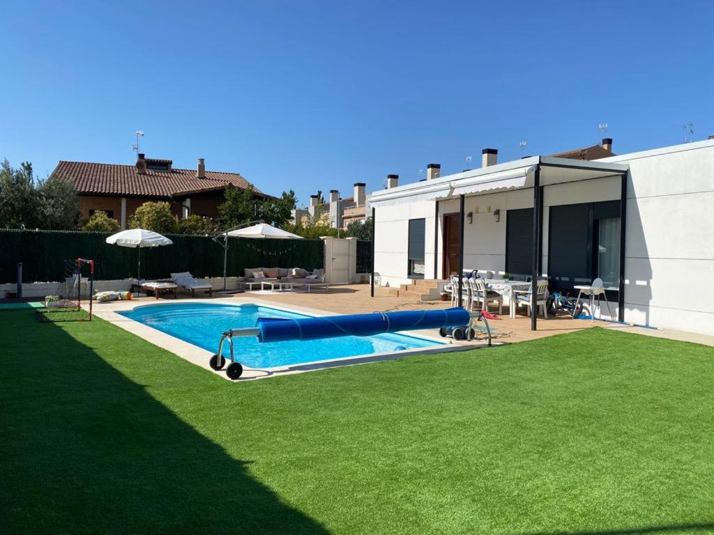 a swimming pool in a yard next to a house at Casa hugo olite in Olite