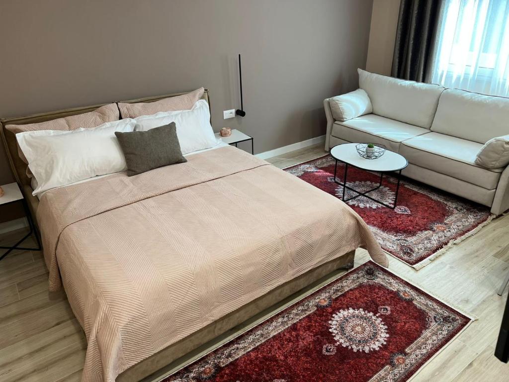 a bedroom with a large bed and a couch at Smart Home , Lovely Apartment in Tirana in Tirana