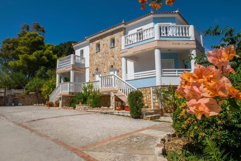 een groot wit gebouw met trappen en balkons bij Agios Sostis Village Apartments in Laganas