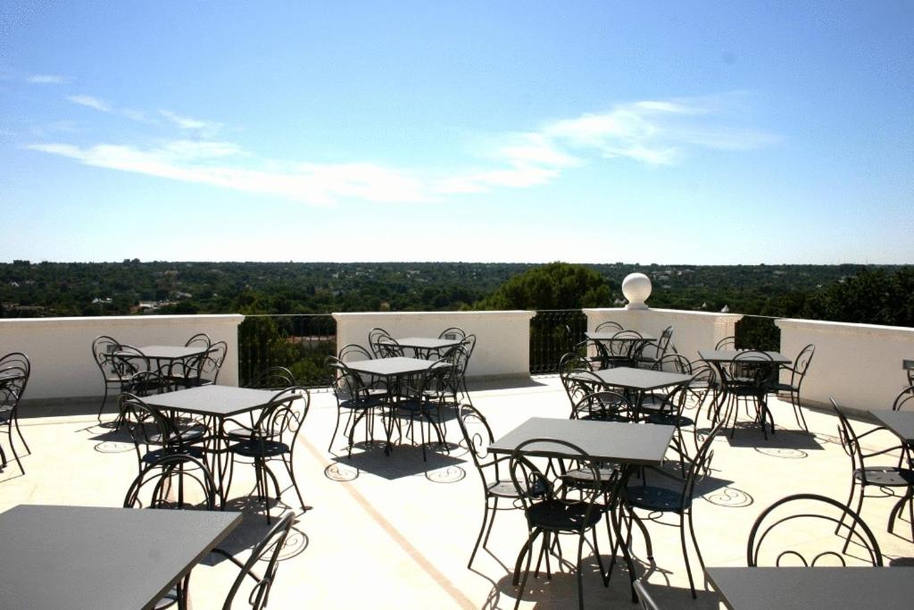 - un ensemble de tables et de chaises sur une terrasse dans l'établissement Hotel Madonna Delle Grazie, à Ceglie Messapica