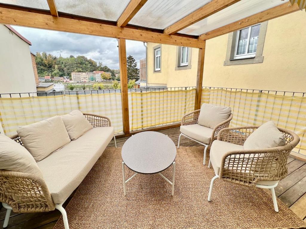 a porch with a couch and chairs and a table at Meißner Elb-Domizil in Meißen