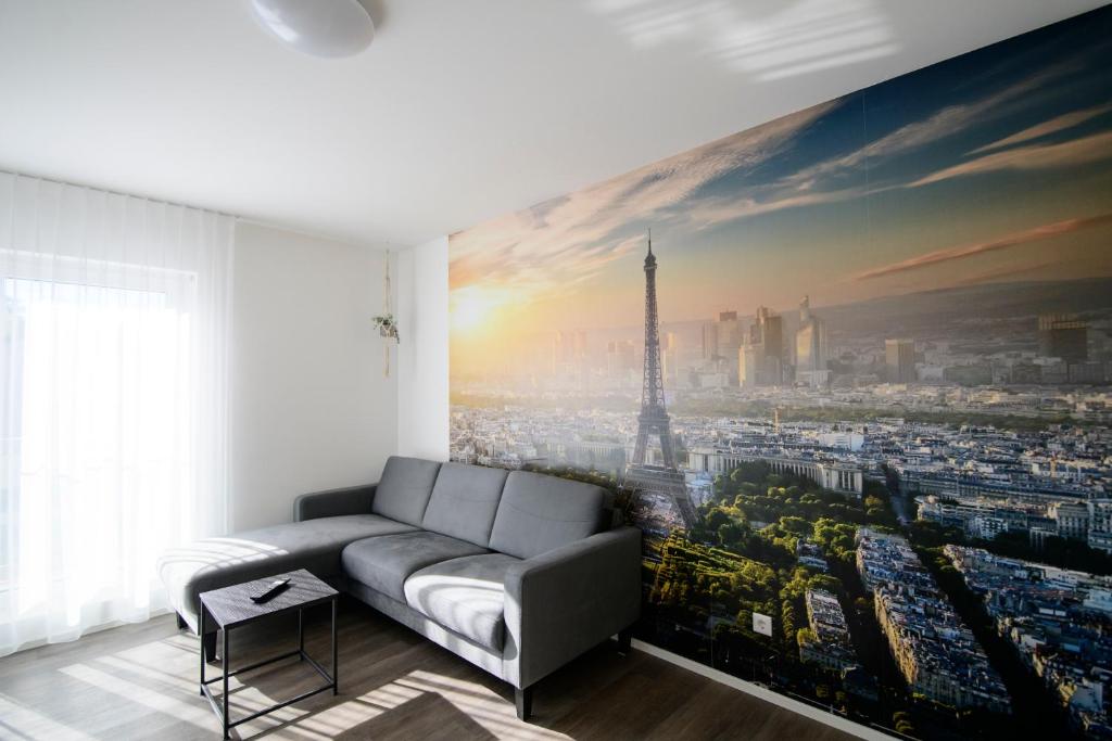 ein Wohnzimmer mit einem großen Gemälde des Eiffelturms in der Unterkunft Smart & Stay Aparthotel Saarbrücken Süd - Self-Check-In - Free Parking in Saarbrücken