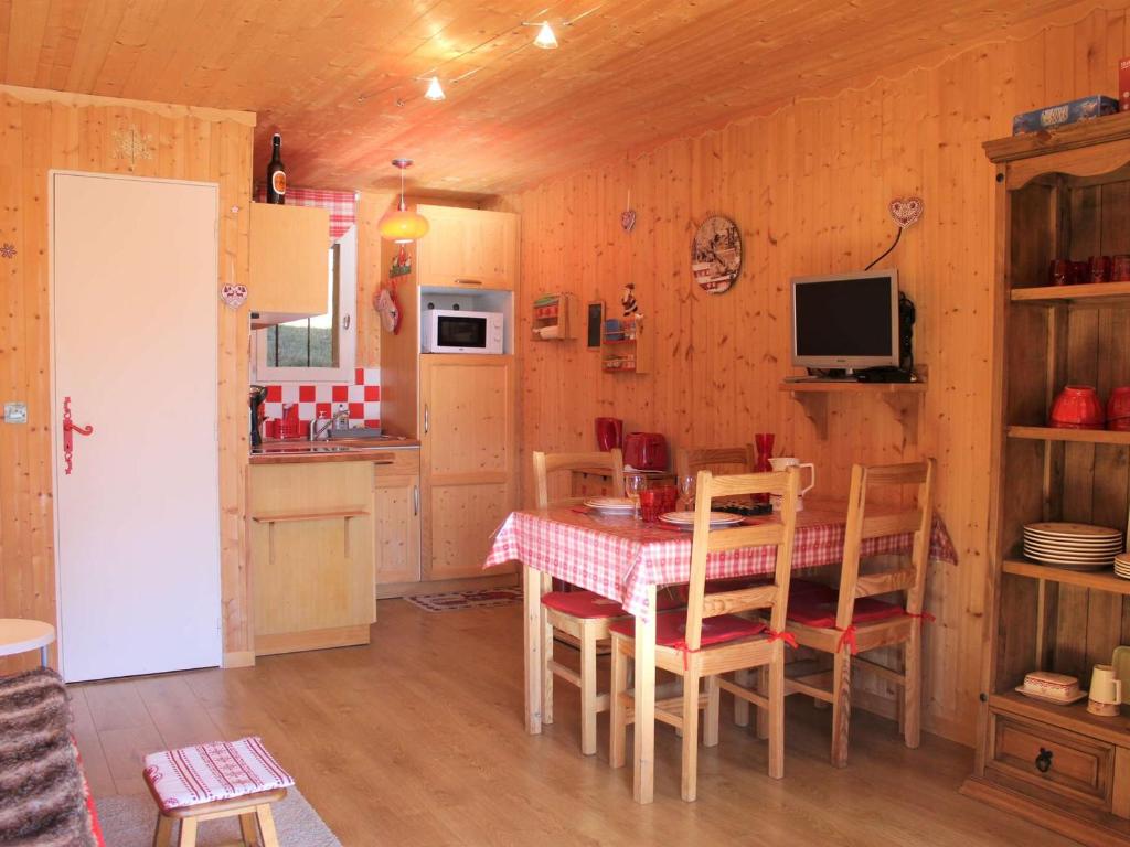 une cuisine et une salle à manger avec une table et des chaises dans l'établissement Charmant studio à Vars Les Claux, proche commodités et pistes, balcon en rez-de-chaussée - FR-1-330B-130, à Vars