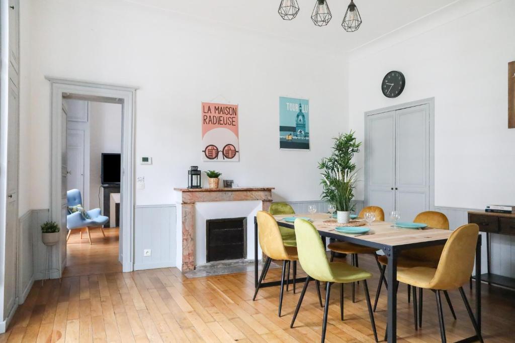 a dining room with a table and yellow chairs at Esprit Feydeau- 2 chambres en bail mobilité in Nantes