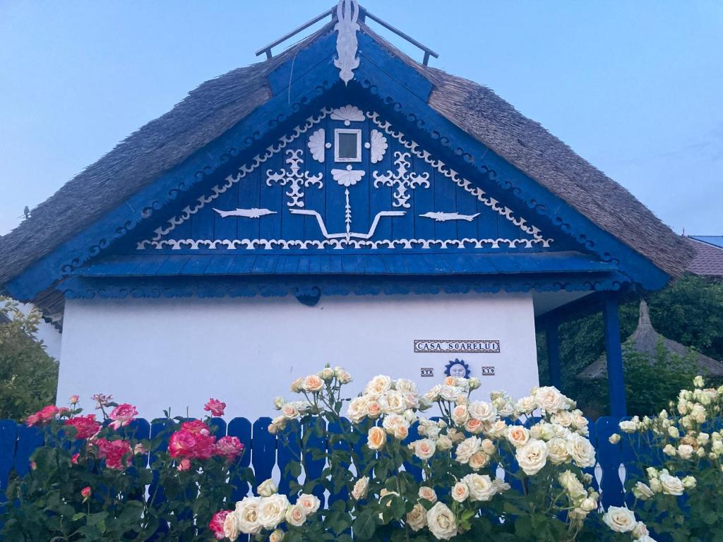 un edificio azul y blanco con flores delante en Casa Soarelui, en Murighiol