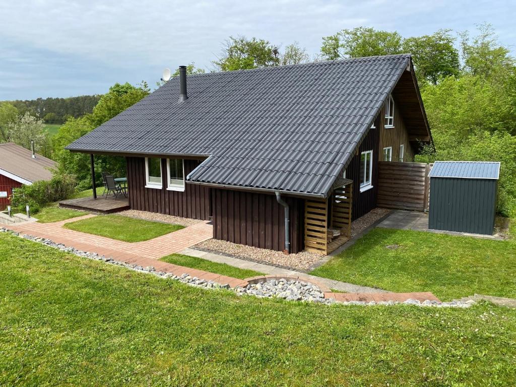 a small house with a black roof at EXTERTAL-FERIENPARK - Premium-Ferienhaus Sonnenhügel #36 in Extertal